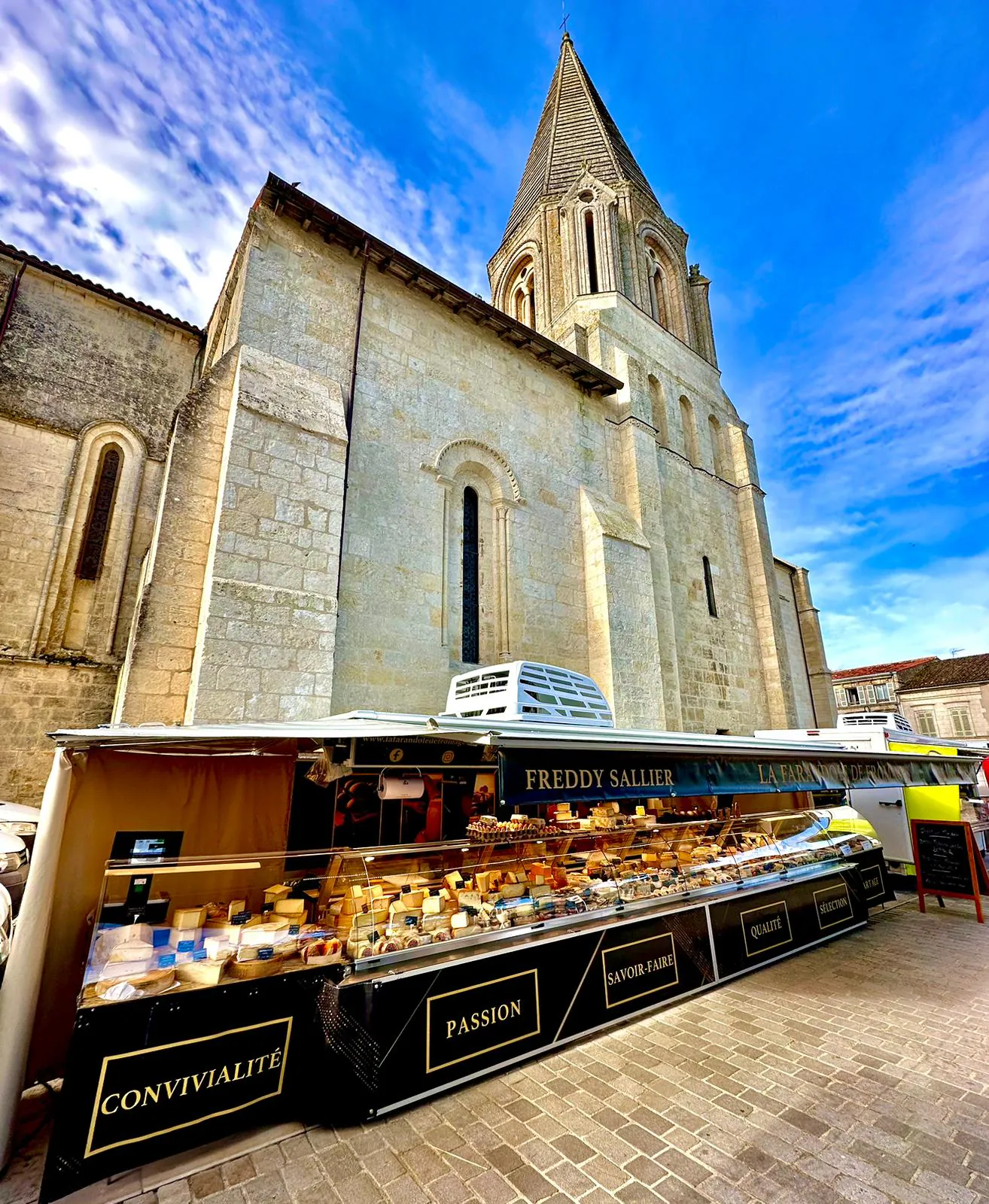 Le stand de La Farandole de Fromages installé sur le marché, devant l'église